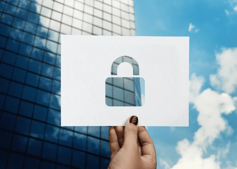 Hand holding a security lock icon against modern building backdrop representing data security